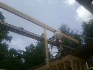 Carpenter setting a ridge beam over a new addition frame — Ice Dam Removal by Roofing Brothers in Bruceton