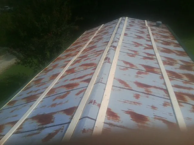 Rusted metal roof panels with new wood purlins before replacement — Storm Damage Roof Repair in Bruceton by Roofing Brothers