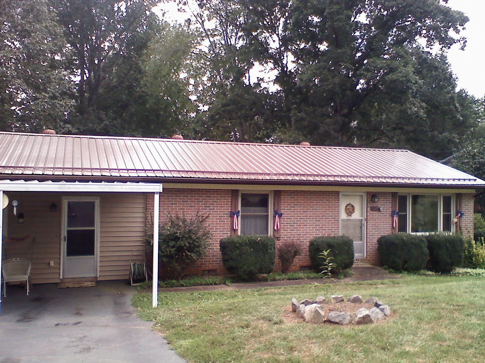 Bronze metal roof and carport on a brick ranch home — Roof Repair work by our crew in Bruceton